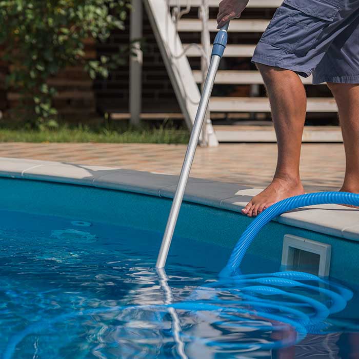 man cleaning a swimming pool