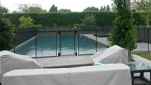 A mesh BABY-LOC fence surrounds a pool.