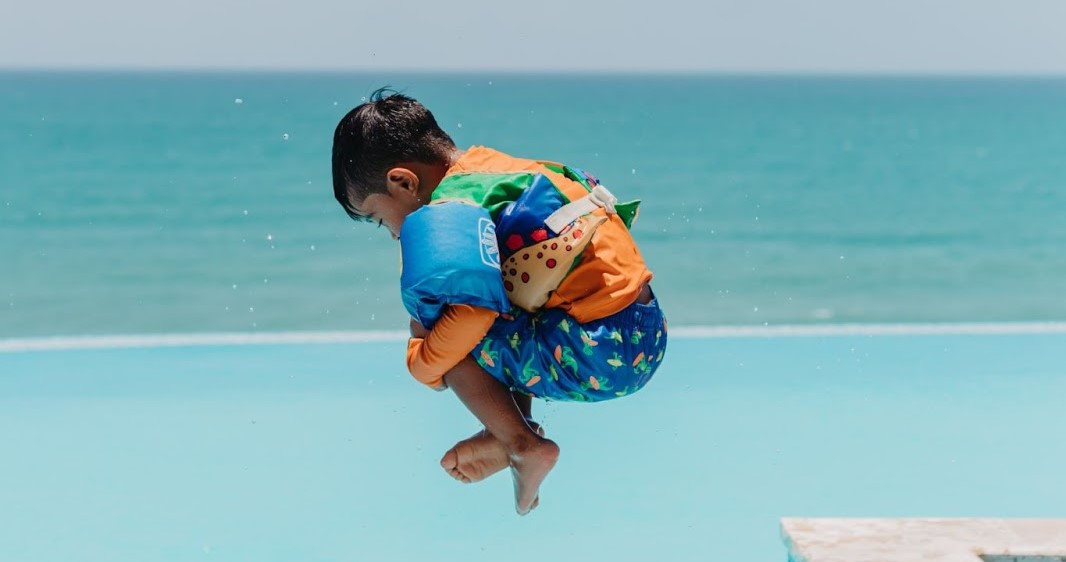 Child jumping into a pool